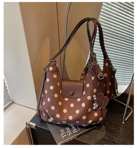 Bruine schoudertas detail met polkadots, zachte stof, klepsluiting en bedel.