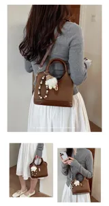 Detailed view of the retro brown shoulder bag featuring chic charm and elegant hardware design.