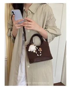 Stylish brown commuter shoulder bag with cute fluffy charm, minimalist crossbody design.