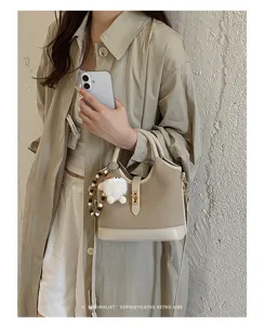 Stylish minimalist canvas shoulder bag for women, chic retro commuting handbag with top handle.