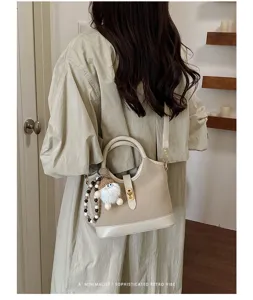 Minimalist retro two-tone handbag with chic plush charm and shoulder strap for daily commuting.