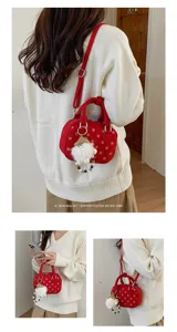 Red polka dot bowling bag detail showcasing cute plush keychain pendant and adjustable strap.