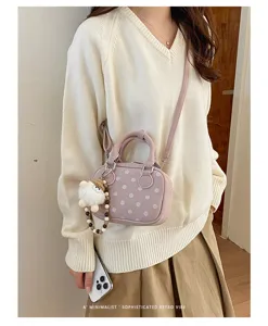 Korean style pink polka dot bowling handbag with cute plush charm and crossbody strap.