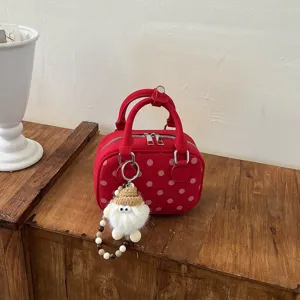 Red polka dot bowling bag with cute plush gnome keychain, stylish vintage handbag for women.