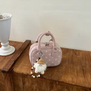 Pink polka dot bowling handbag with plush charm, trendy casual commuter shoulder crossbody bag.