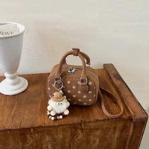 Brown polka dot handbag detail, cute plush doll keychain, vintage style shoulder crossbody bag.