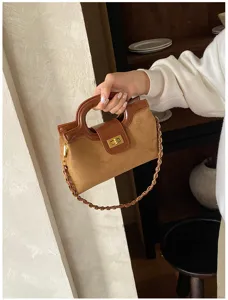 Vista dettagliata dell'elegante borsa in camoscio marrone e pelle con tracolla a catena.