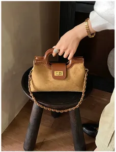 Borsa a mano e tracolla in camoscio marrone con chiusura a torsione ed elegante catena.