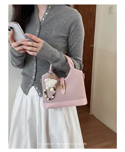 Stylish pink top-handle shoulder bag for women, elegant retro commuter crossbody design.