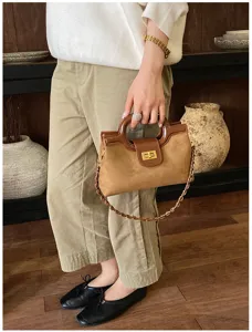 Borsa a mano da donna in pelle marrone con manico rotondo e catena dorata elegante