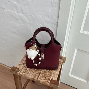 Maroon commuter handbag with cute gnome keychain, ideal for daily office and fashion use.