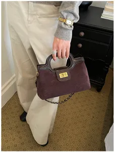 Borsa a mano in camoscio marrone con chiusura a girello dorata vintage e tracolla a catena.
