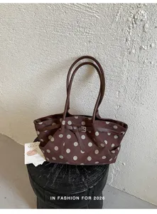 Vista dettagliata della borsa tote marrone a pois con doppi manici e raffinato dettaglio fibbia.