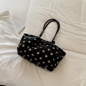 Elegante borsa shopper nera in tela con pois bianchi, vista dettagliata per uso quotidiano.