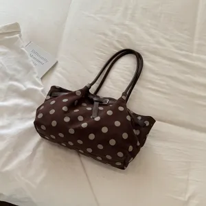 Dettaglio della borsa shopper marrone a pois con tessuto morbido, manici e fibbia.