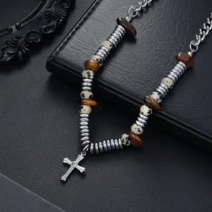 Vue détaillée du collier pendentif croix de niche avec perles métalliques et pierres naturelles.