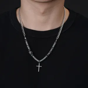 Vue détaillée du collier pendentif croix avec des tubes métalliques uniques et des perles.
