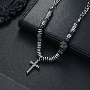 Collier pendentif croix gothique avec perles métalliques cannelées et pierres sombres.