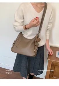 Stylish brown leather hobo shoulder bag with cute heart charm, perfect for daily commuting.