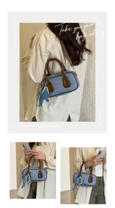 Detailed view of stylish denim boston shoulder bag with brown leather trim and starfish charm.