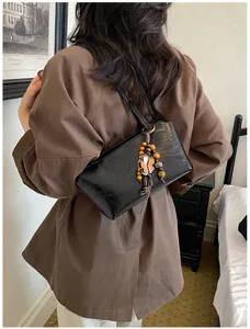 Modische koreanische schwarze Umhängetasche für Damen mit Holzperlen Blumenanhänger.