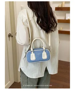 Detailed view of the stylish denim and white leather Boston shoulder bag with retro vintage aesthetic.