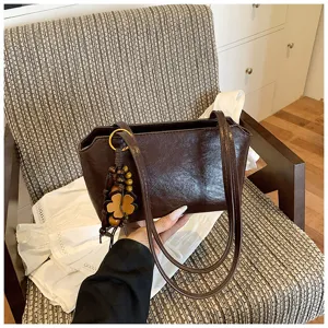 Elegante dunkelbraune Umhängetasche mit Holzanhänger, schicke minimalistische Damentasche.