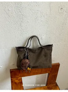 Detailansicht einer lässigen braunen Wildleder-Tasche mit Karomütze für den Alltag.