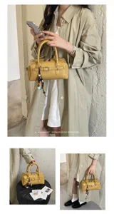 Minimalist retro yellow bowling handbag with chic beaded charm and structured pillow design.