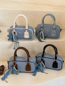 Stylish denim Boston handbag with contrast color handles and cute star pearl charm for women.
