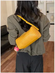 Stijlvolle gele geweven schoudertas voor dames, chique okseltas met leuke hanger.
