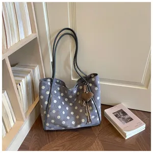 Vue détaillée du sac cabas élégant à pois gris avec un charmant pendentif cœur en tricot.