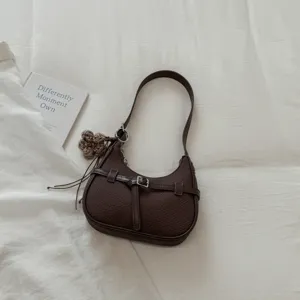 Bolso de hombro de media luna marrón oscuro tejido con hebilla retro y colgante de flor.