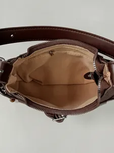 Bolso de hombro de media luna en cuero marrón, vista superior que muestra interior y cremallera.