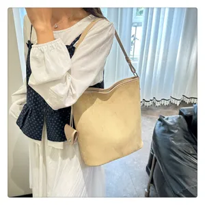 Vista dettagliata della borsa a secchiello in camoscio da donna stile vintage minimalista.