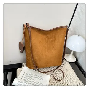 Dettaglio borsa a tracolla in camoscio marrone, borsa secchiello vintage casual