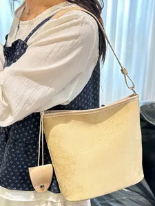 Borsa a secchiello minimalista vintage in camoscio da donna, elegante tracolla beige.