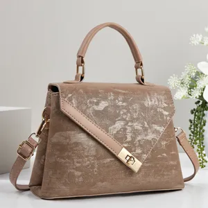 Détail du sac à main taupe pour femme élégant avec texture texturée unique et finitions dorées.