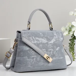 Sac à main texturé gris avec fermeture en métal et bandoulière réglable pour les femmes.
