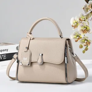 Elegant classic beige leather top handle handbag with adjustable crossbody strap and stylish zippers.