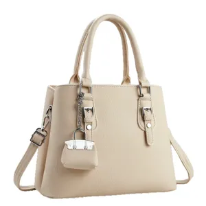 Elegante bolso de mano para mujer beige bolso de hombro con asas y bonito colgante decorativo.