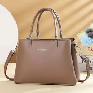 Elegante bruine lederen handtas voor dames, voorzien van handvatten en schouderriem.