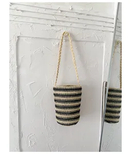 Detailansicht der Stroh-Eimer-Tasche, schwarz-weiße, lässige Damen-Umhängetasche.