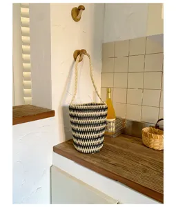Schwarz-weiße gestreifte Stroh-Eimer-Tasche, geflochtener Schultergurt, Vintagedetail.