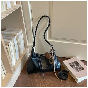 Sac à épaule vintage noir pour femme, sac hobo rétro en cuir souple avec bandoulière tressée.