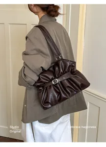Vue détaillée du sac porté épaule plissé marron en cuir souple avec boucle métallique.
