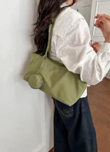 Detailed shot of casual shoulder tote bag with small coin purse, daily commute style.