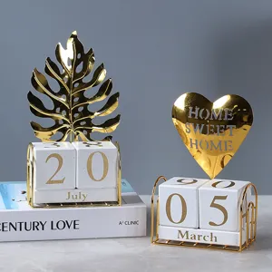 Luxury metal block perpetual calendar with monstera leaf and heart decor for desk decoration.