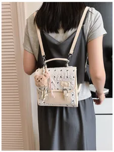 Detail view of stylish women mini backpack with cute bear pendant and bow patterns, casual bag.