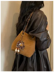 Retro brown suede bucket bag for women, stylish single shoulder messenger bag with floral charm.